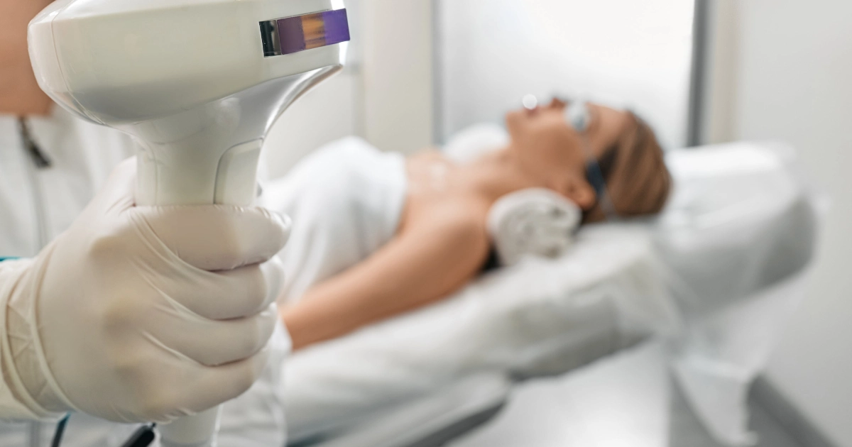 Close-up of a gloved hand holding a Lumecca IPL device in St Petersburg during a light therapy session.