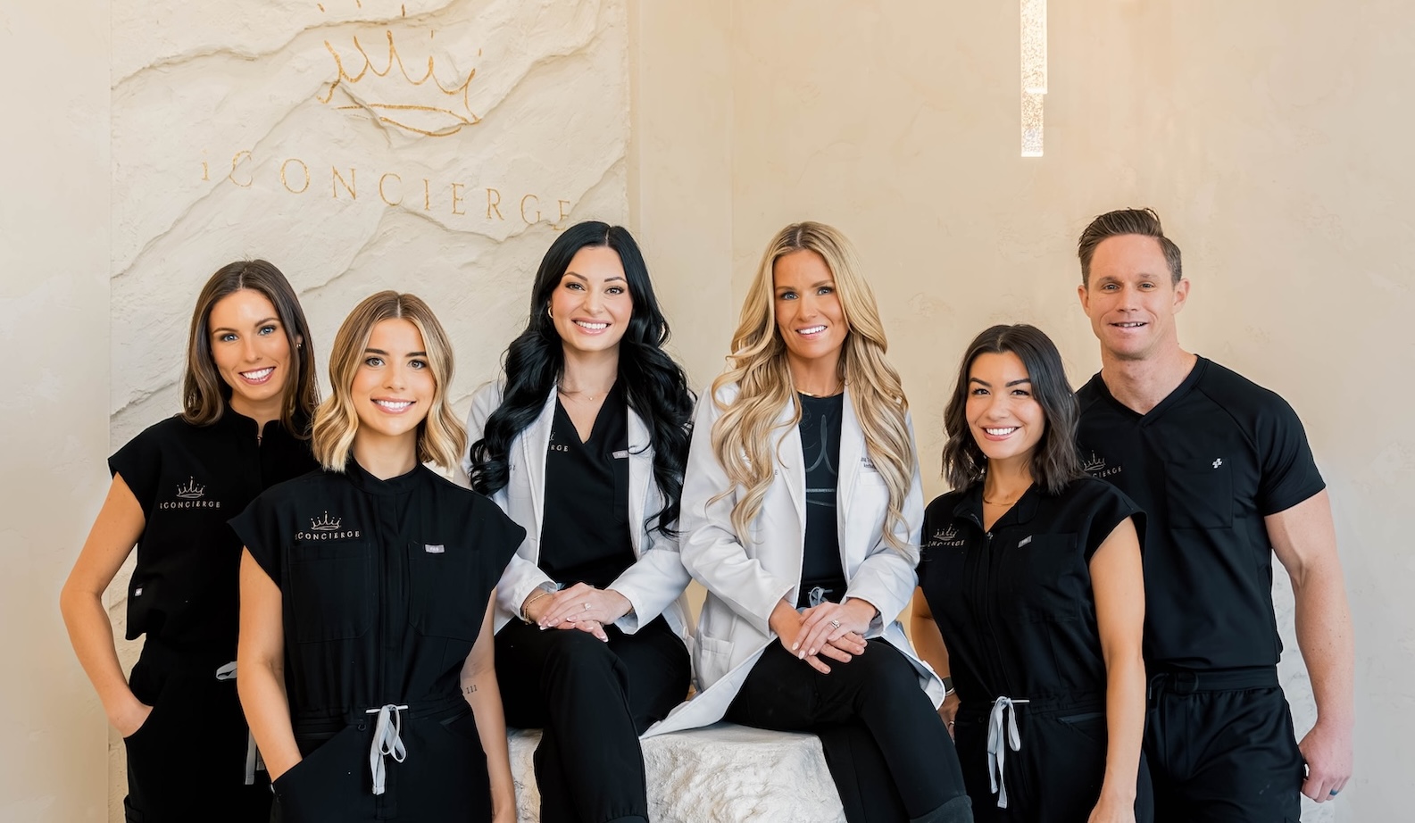  The iConcierge Med Spa team of providers pose for a portrait photo in their sleek and elegant entry. They include the professionals who deliver medically-supervised cheek filler in St. Petersburg